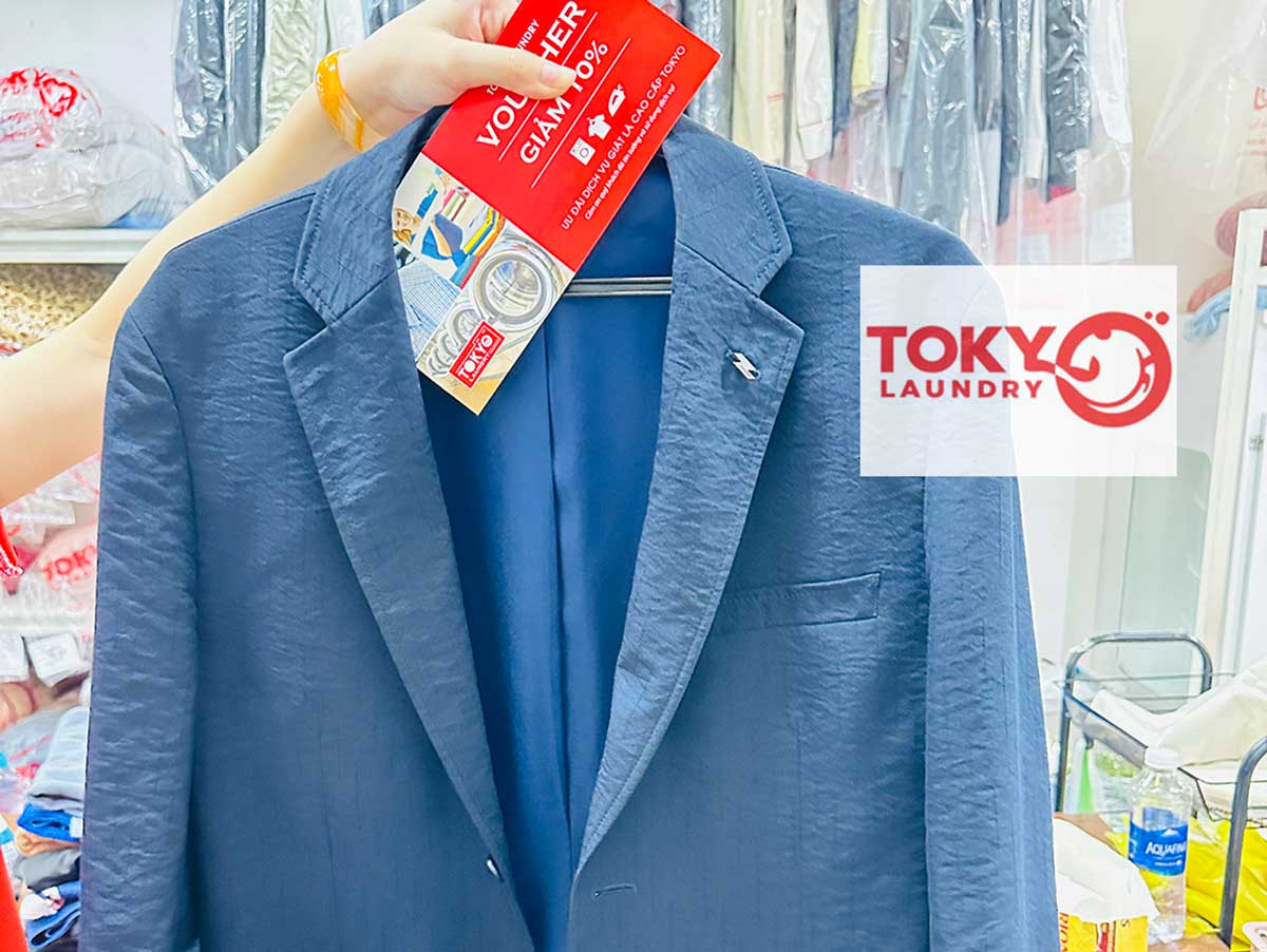Áo vest xanh sạch đẹp treo kèm thẻ ưu đãi tại tiệm giặt áo vest tại phố 8/3