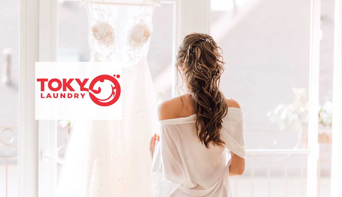 Cô dâu đứng ngắm chiếc váy cưới trắng bồng bềnh sau khi sử dụng dịch vụ giặt váy cưới tại Lê Thanh Nghị